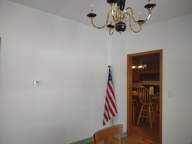 hall with wood finished floors and an inviting chandelier