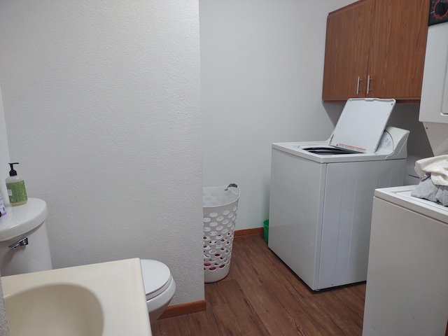 laundry room featuring washing machine and clothes dryer, baseboards, wood finished floors, laundry area, and a sink