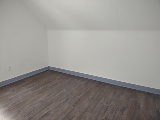 bonus room featuring baseboards, lofted ceiling, and dark wood finished floors