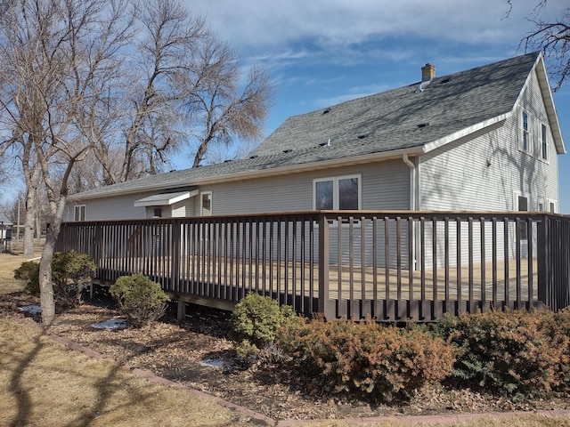 back of property with roof with shingles and a wooden deck
