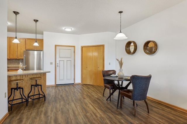 dining area with a textured ceiling and dark wood-type flooring