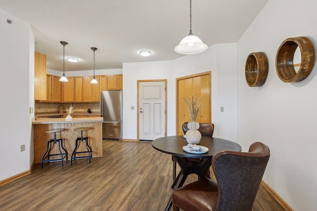 dining room with dark hardwood / wood-style flooring and a textured ceiling