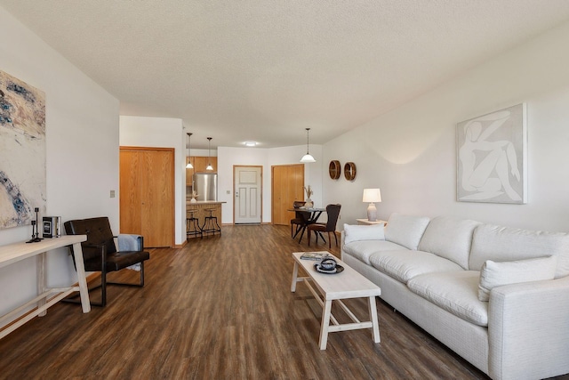 living room featuring dark hardwood / wood-style flooring and a textured ceiling