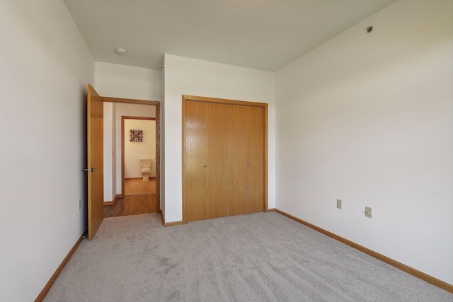 unfurnished bedroom featuring light carpet and a closet