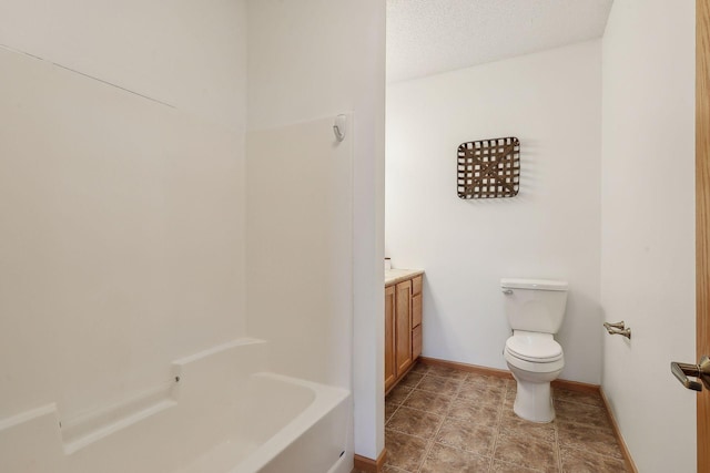 bathroom with vanity, a textured ceiling, and toilet