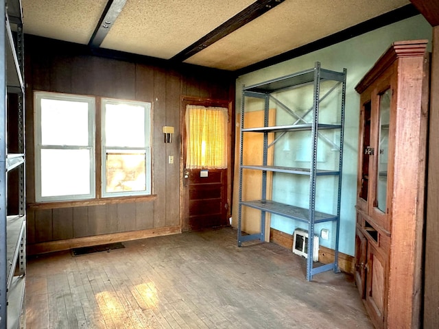 interior space featuring wood-type flooring, a textured ceiling, and wood walls