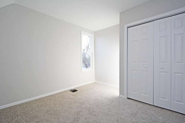 unfurnished bedroom with a closet and light carpet