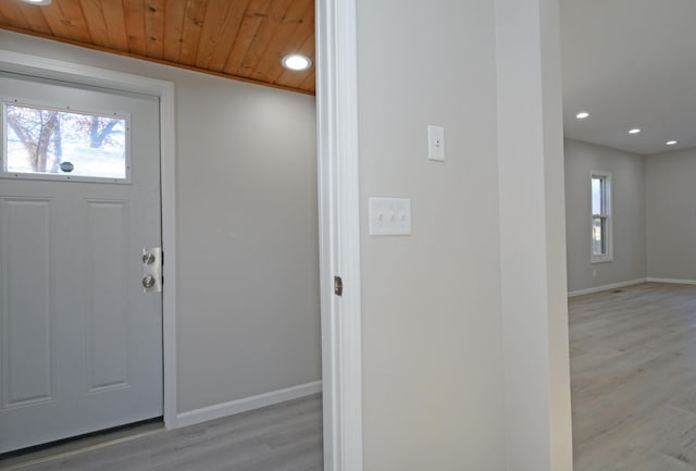 entryway featuring light wood-type flooring, wooden ceiling, and plenty of natural light