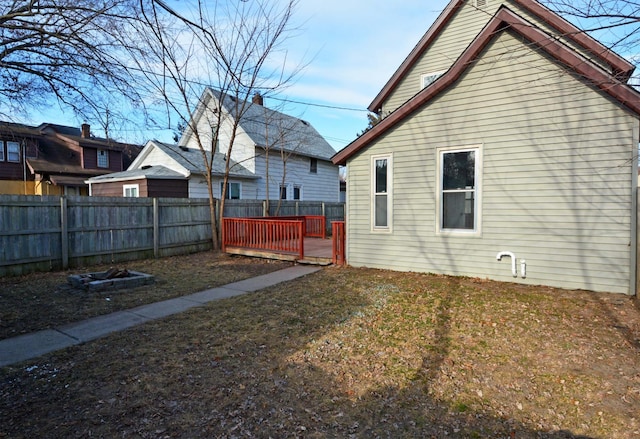 rear view of house featuring a deck and a lawn