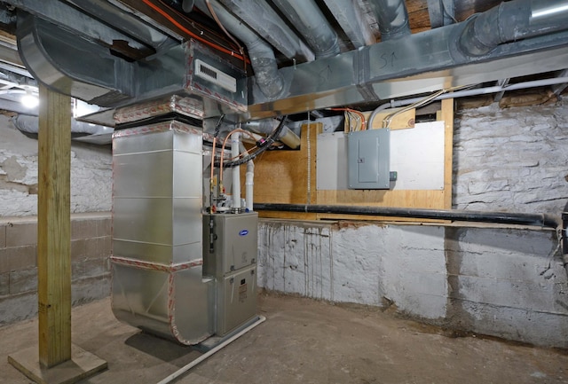 utility room featuring electric panel and heating unit