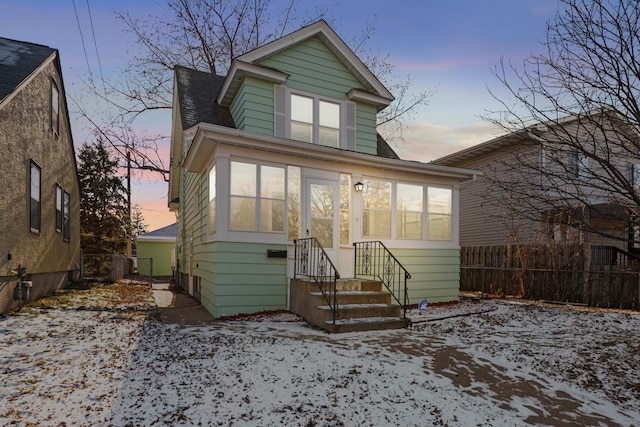 snow covered property featuring a sunroom