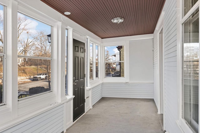 unfurnished sunroom featuring plenty of natural light and wood ceiling