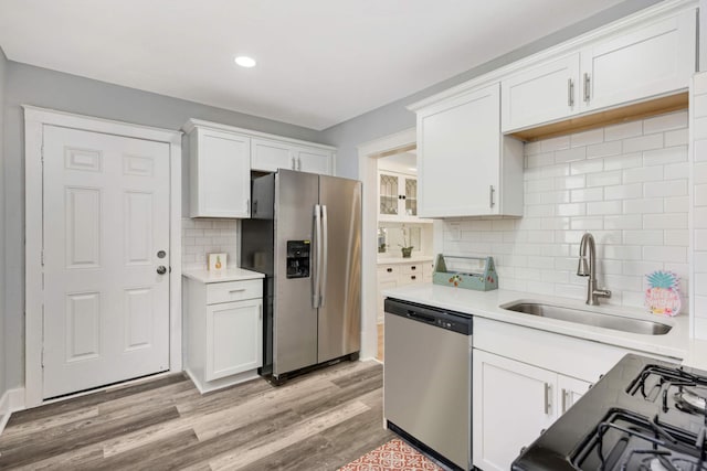 kitchen featuring stainless steel appliances, white cabinets, tasteful backsplash, and sink