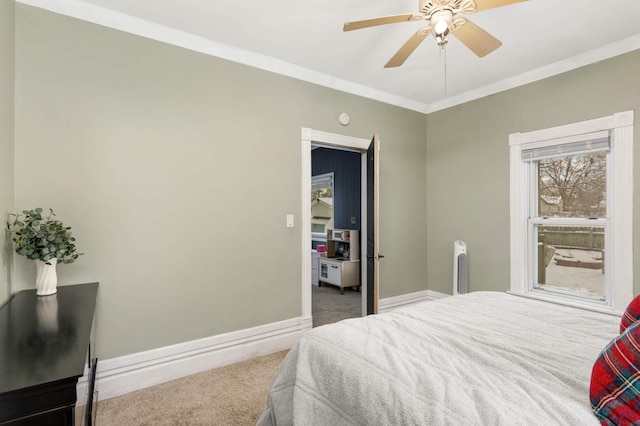 carpeted bedroom featuring ceiling fan and ornamental molding