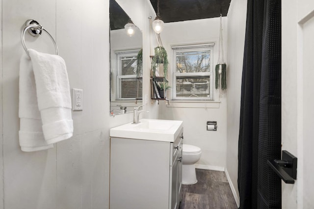 bathroom with hardwood / wood-style flooring, toilet, and vanity