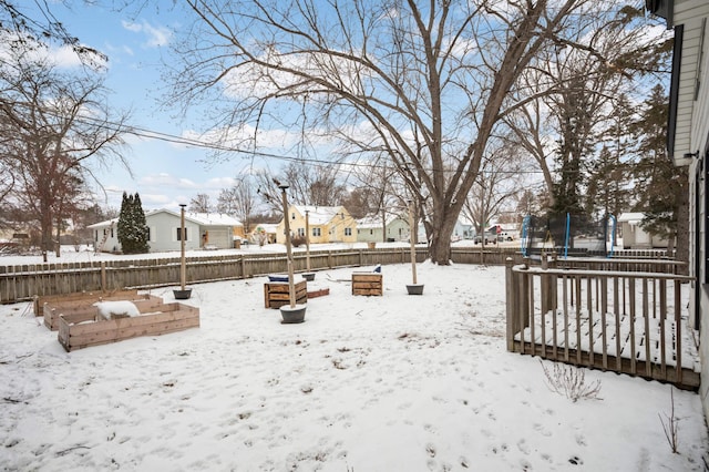 yard layered in snow featuring a trampoline