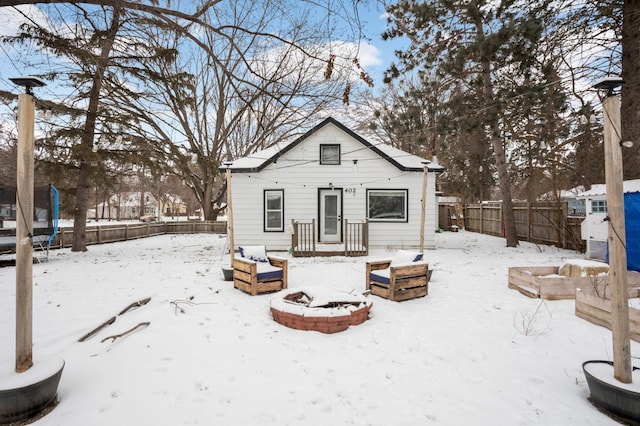 snow covered house featuring a trampoline