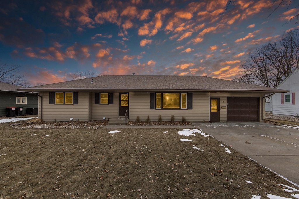 ranch-style home featuring a garage and a yard