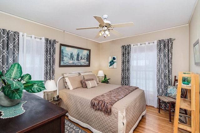 bedroom featuring ceiling fan, ornamental molding, and light hardwood / wood-style floors