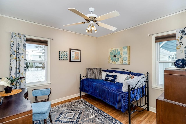 bedroom with ceiling fan, hardwood / wood-style floors, and multiple windows