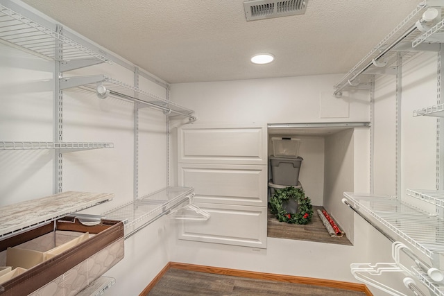 spacious closet featuring dark hardwood / wood-style floors