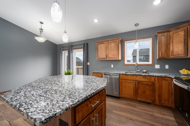 kitchen featuring brown cabinetry, electric range oven, a kitchen island, stainless steel dishwasher, and a sink