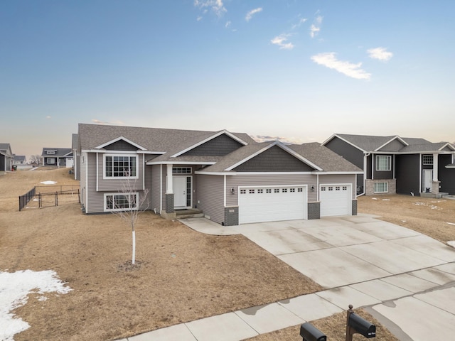 view of front of house featuring a shingled roof, concrete driveway, an attached garage, fence, and a residential view