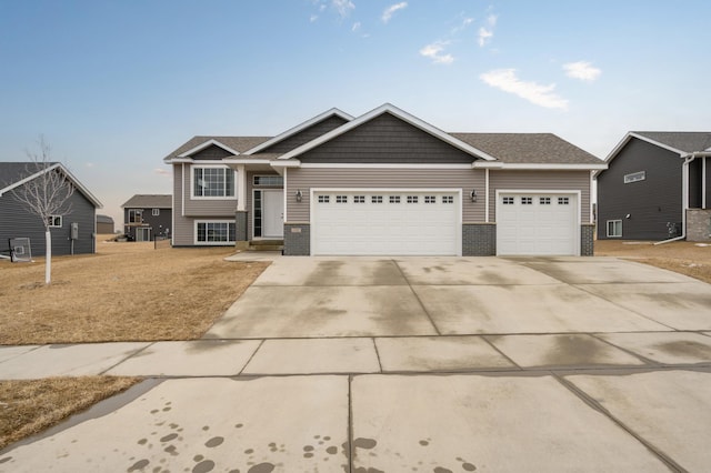 view of front of house with an attached garage, driveway, and brick siding