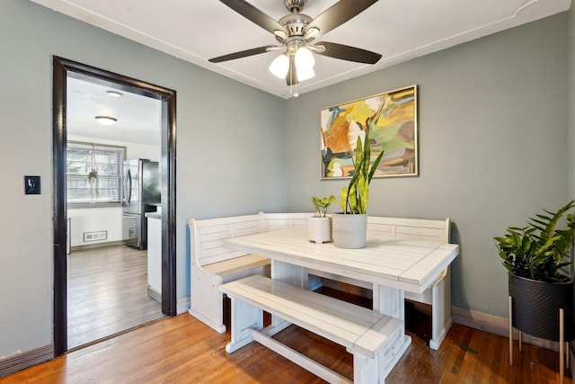 dining area with wood-type flooring and ceiling fan