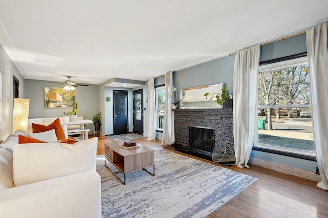 living room featuring ceiling fan, a fireplace, and hardwood / wood-style floors