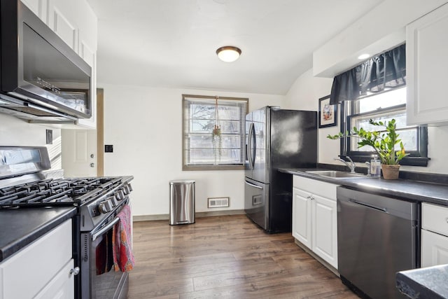 kitchen featuring stainless steel appliances, dark hardwood / wood-style floors, sink, and white cabinets