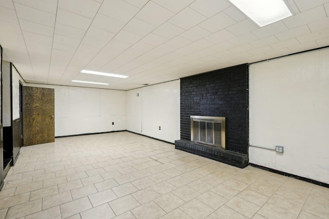 basement with a brick fireplace and light tile patterned floors