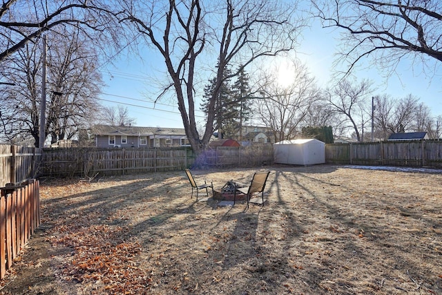 view of yard with a storage shed and an outdoor fire pit