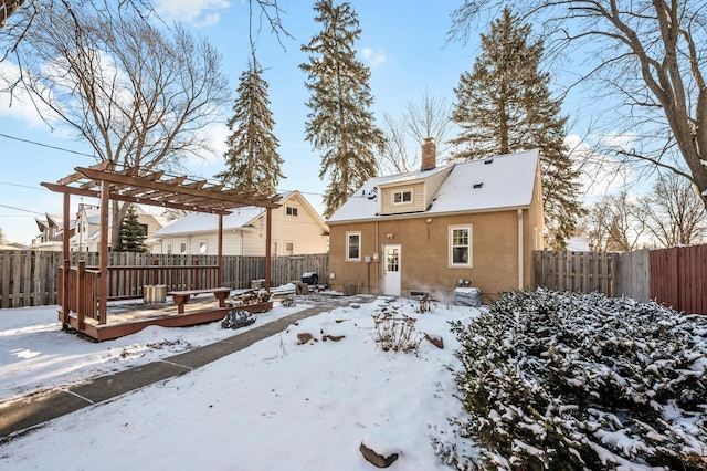 snow covered back of property featuring a deck