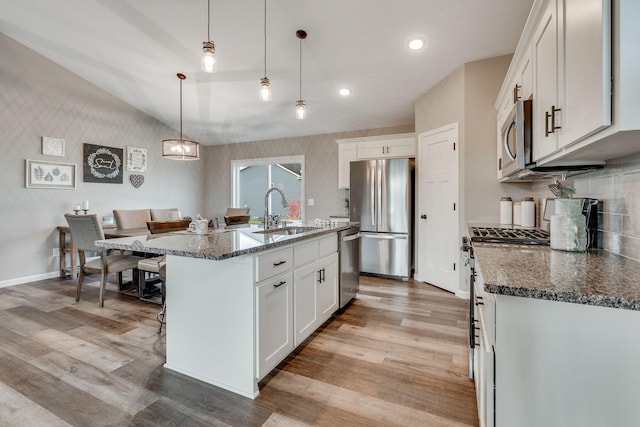 kitchen featuring sink, a center island with sink, white cabinetry, and appliances with stainless steel finishes