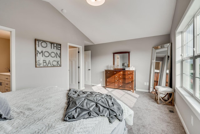 carpeted bedroom with vaulted ceiling and connected bathroom