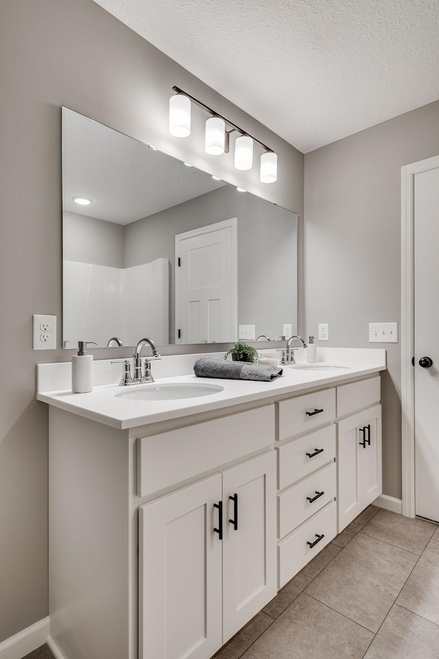 bathroom featuring tile patterned floors, vanity, and a textured ceiling