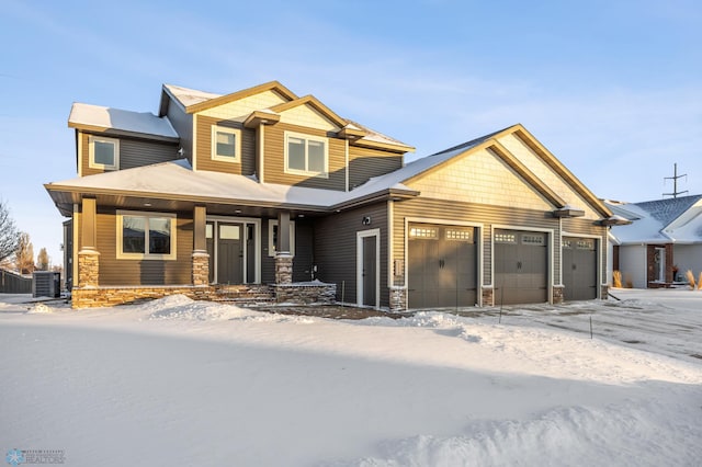 craftsman-style home with a porch, central AC unit, and a garage