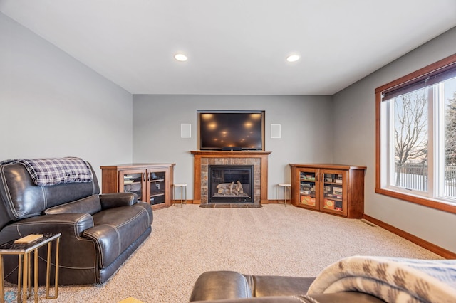 living room with a tiled fireplace and light carpet