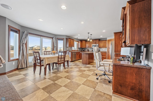 kitchen with stainless steel appliances, a breakfast bar area, decorative light fixtures, and a center island