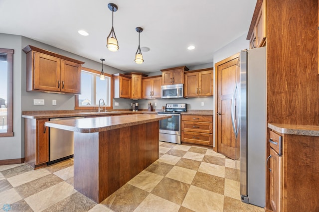 kitchen featuring a kitchen island, appliances with stainless steel finishes, decorative light fixtures, and sink