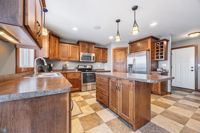 kitchen with pendant lighting, stainless steel appliances, a kitchen island, a breakfast bar area, and sink