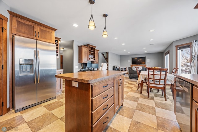 kitchen featuring decorative light fixtures, appliances with stainless steel finishes, and a center island