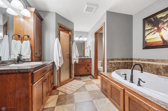 bathroom featuring toilet, vanity, and a washtub