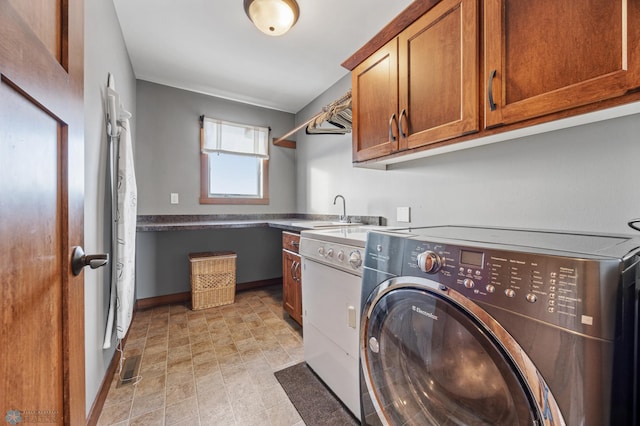 washroom featuring cabinets, washing machine and clothes dryer, and sink