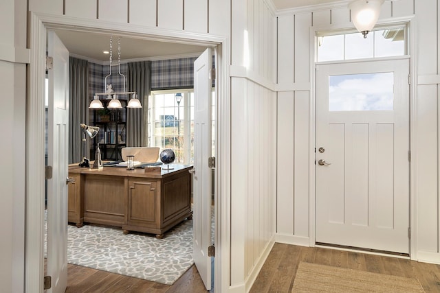 foyer featuring hardwood / wood-style floors and crown molding