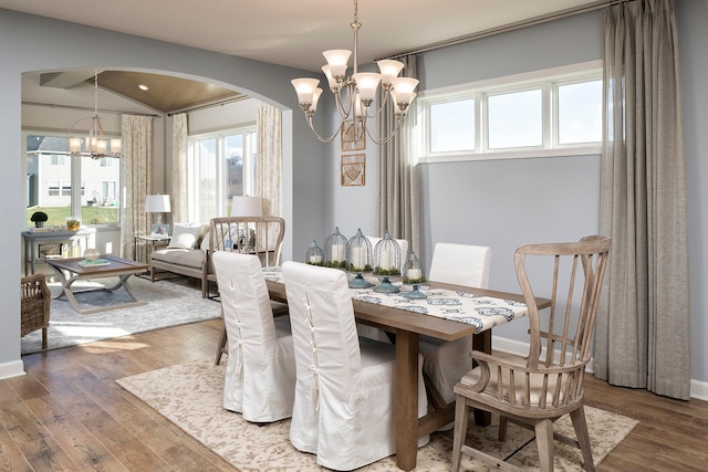 dining area featuring vaulted ceiling, a chandelier, and hardwood / wood-style floors