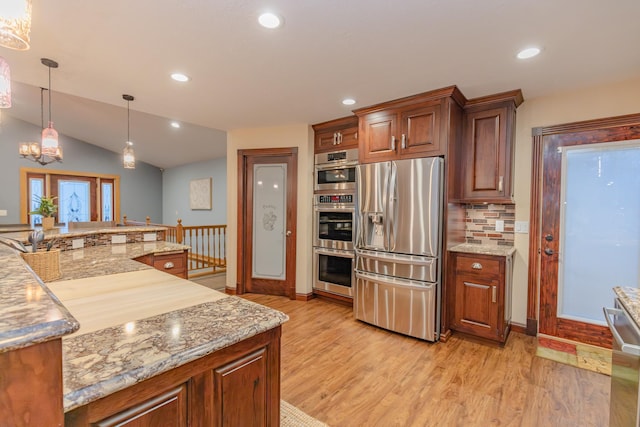 kitchen with tasteful backsplash, lofted ceiling, hanging light fixtures, light hardwood / wood-style floors, and stainless steel appliances