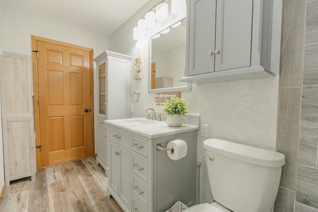 bathroom featuring vanity, hardwood / wood-style floors, and toilet