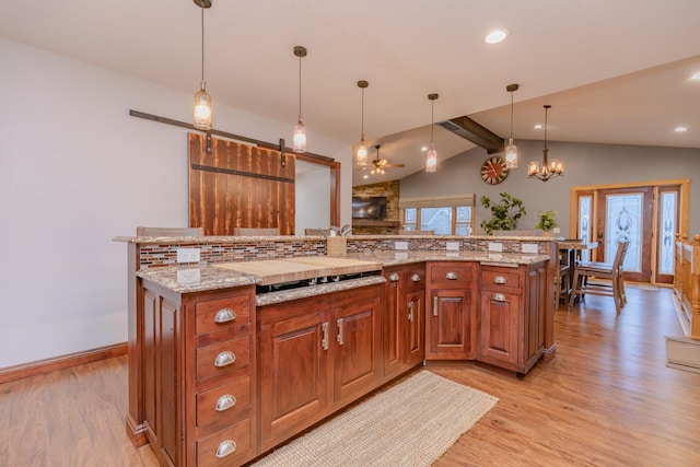 kitchen with vaulted ceiling with beams, decorative light fixtures, light hardwood / wood-style flooring, and light stone countertops